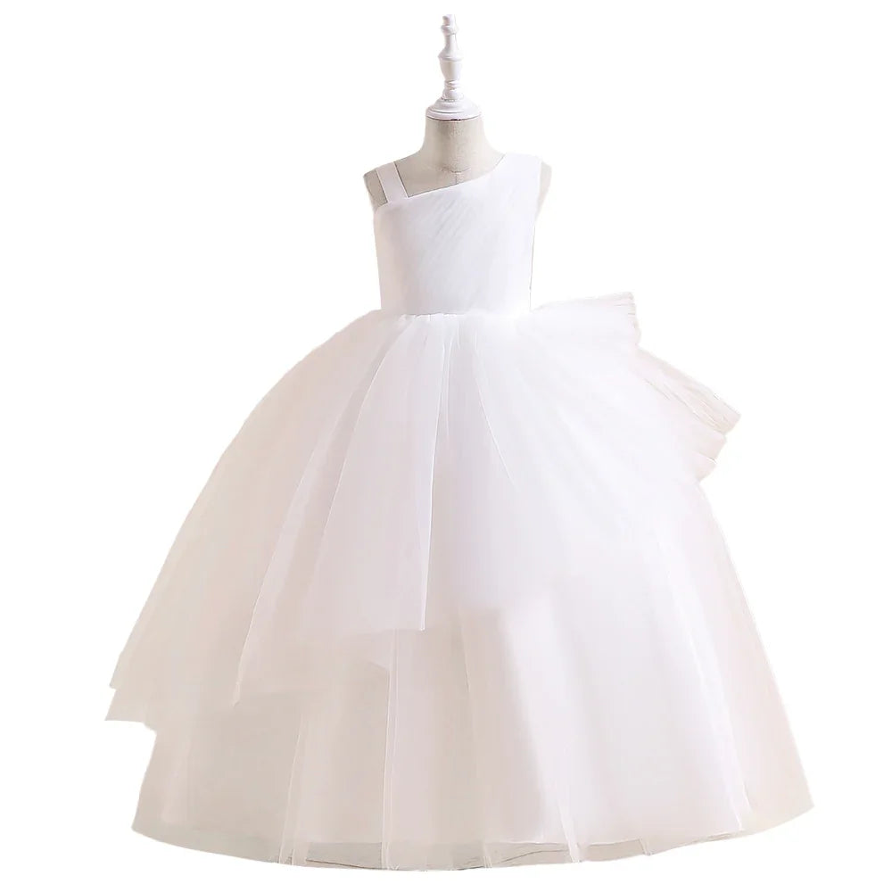 Girls' white tulle ball gown with asymmetric neckline, displayed on dress form