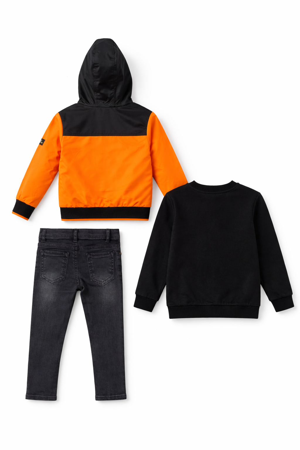A back view showcasing the fit and design of the boys' 3-piece New York City clothing set, featuring the orange and black hooded jacket and dark denim jeans from Trendy Angels Boutique.