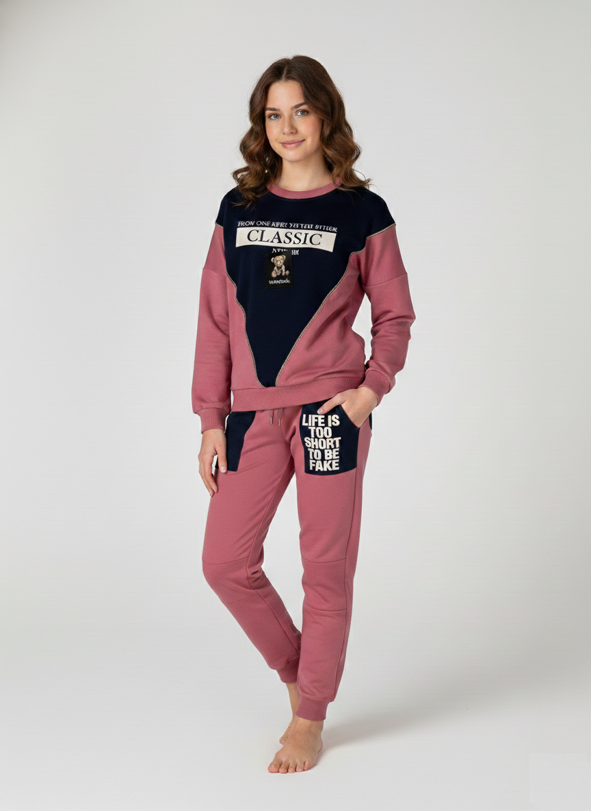 Full-length view of a girl wearing a dusty rose and navy blue "Classic" lounge set featuring graphic patches and "Life is too short to be fake" pocket detail at Trendy Angels Boutique in Brunswick.