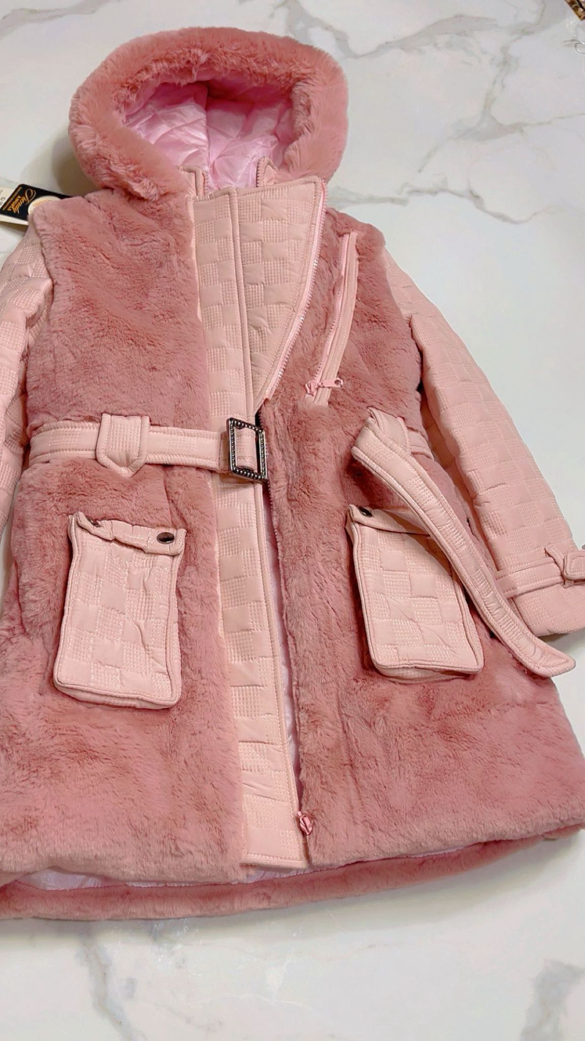 Flat lay of the Isabella girls' rose pink faux fur coat with the front zip open, revealing the smooth satin lining, quilted interior trim, and plush hooded collar.