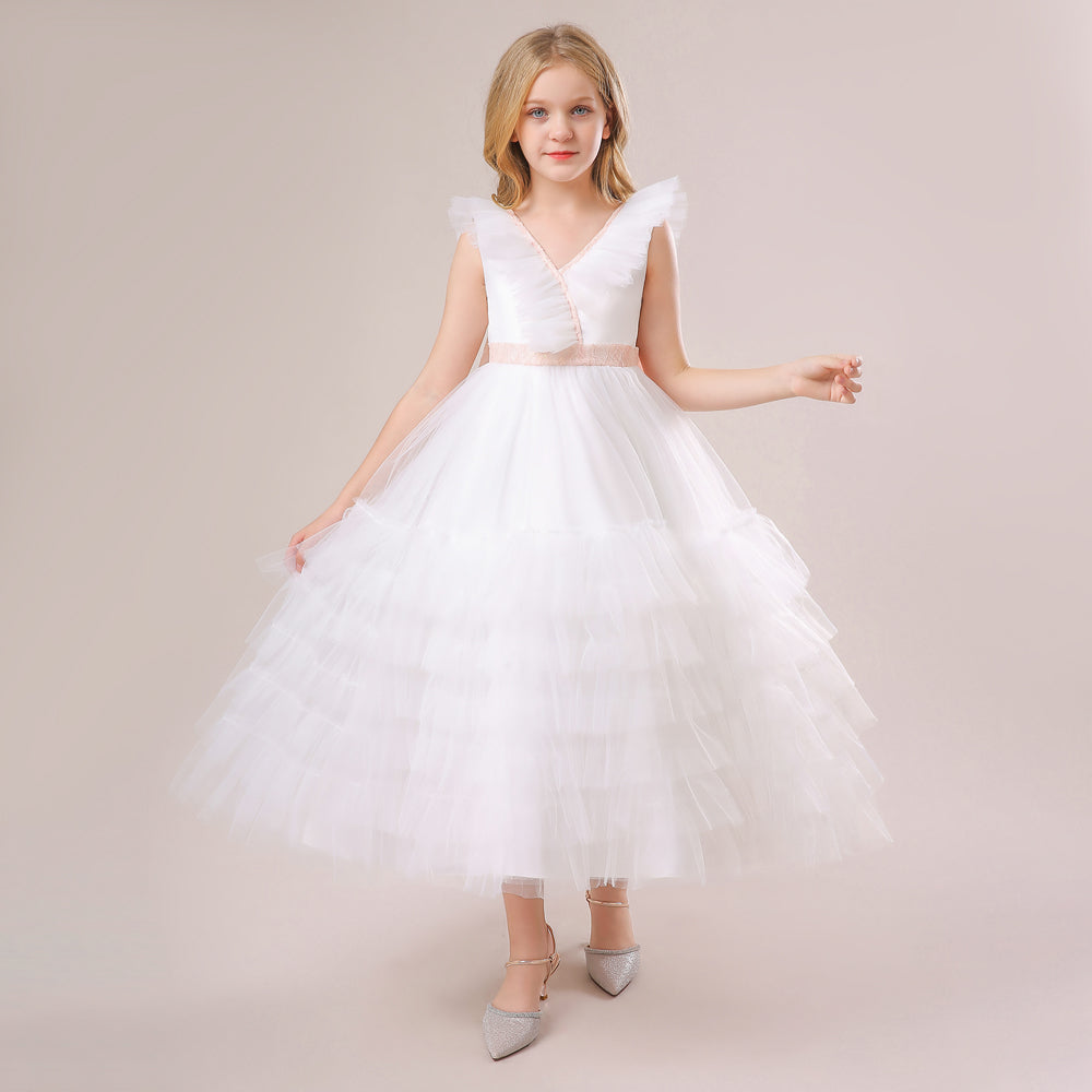 An elegant white junior bridesmaid dress featuring a tiered ruffle skirt and a pink satin belt. Perfect for Melbourne weddings. Shop the collection at Trendy Angels Boutique, 533 Sydney Rd Brunswick