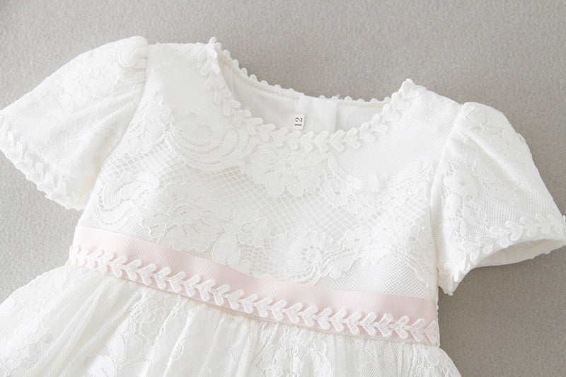 Close-up top view of a baby girl's white baptism dress featuring an intricate floral lace bodice, puff sleeves, and a soft pink ribbon waist, available at Trendy Angels Boutique, 533 Sydney Rd Brunswick Melbourne.