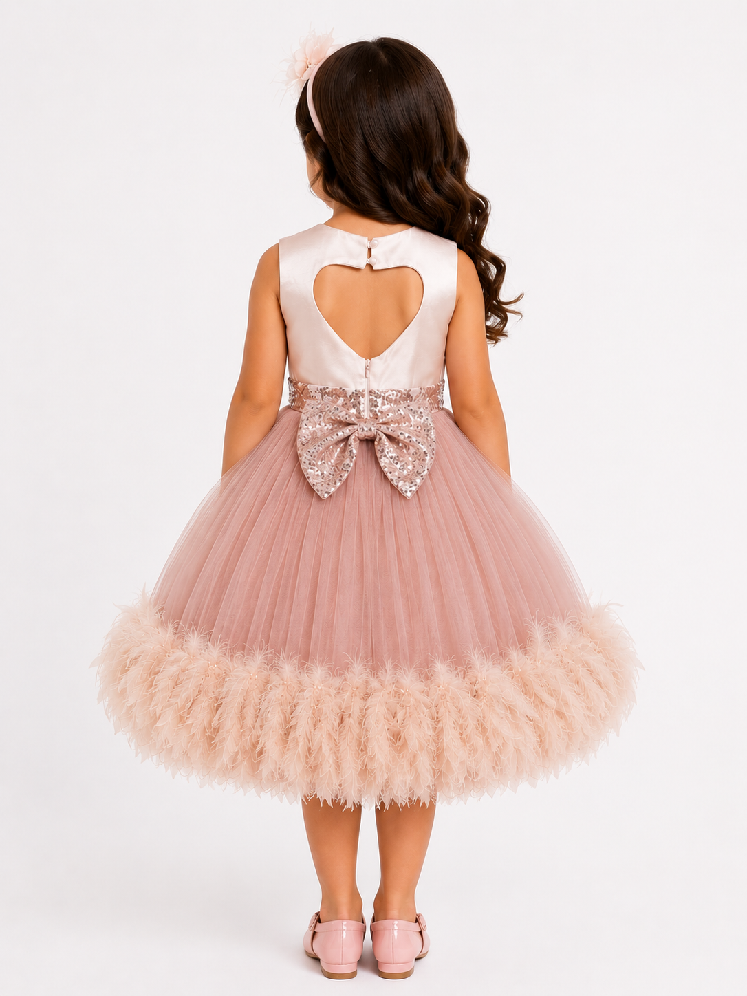 Back view of girl model wearing dusty rose princess dress showing heart shape cut out back design and shimmering sequin bow