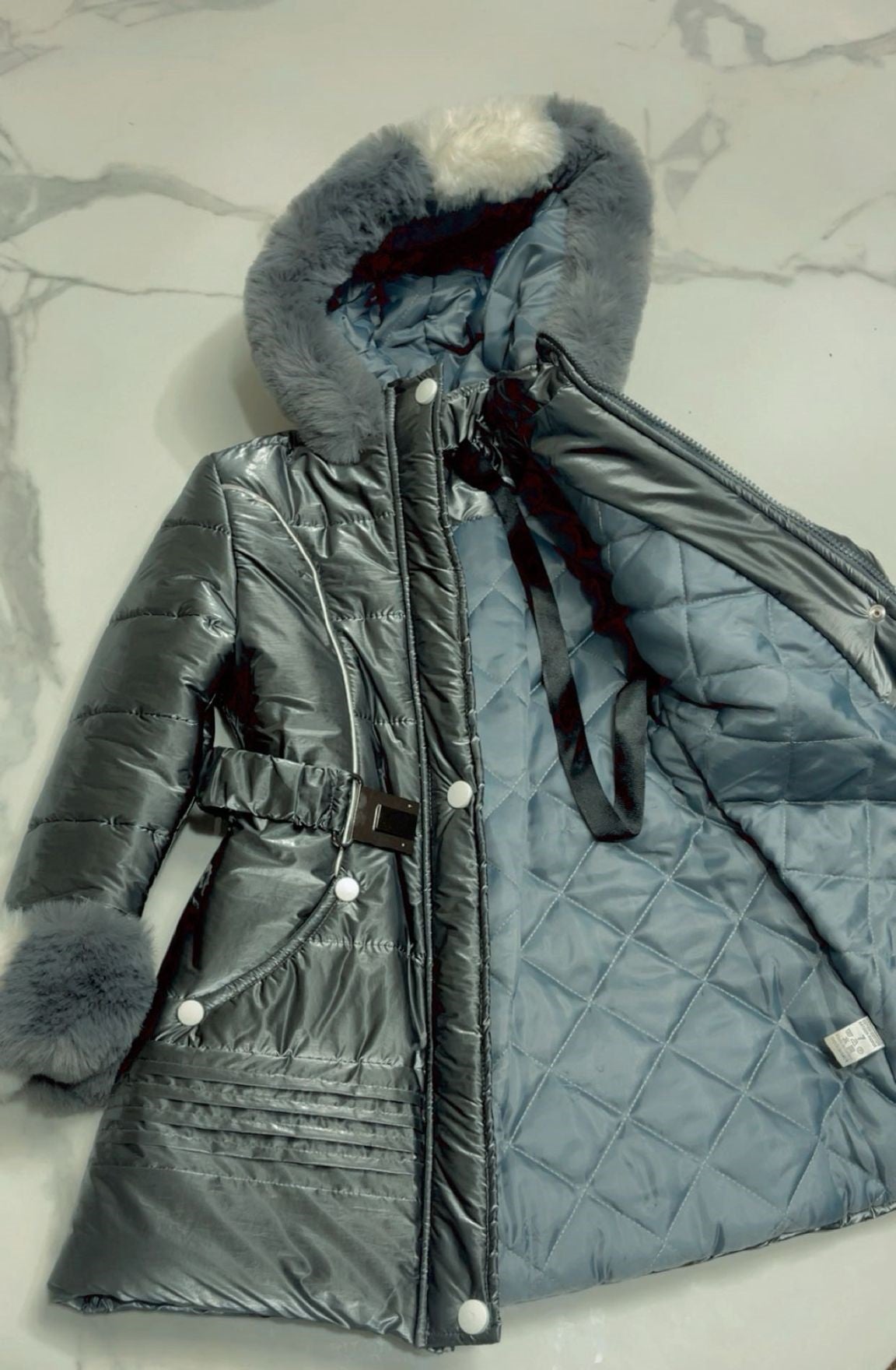 Inside view of girls black puffer jacket showing the warm quilted inner lining and premium stitching detail.