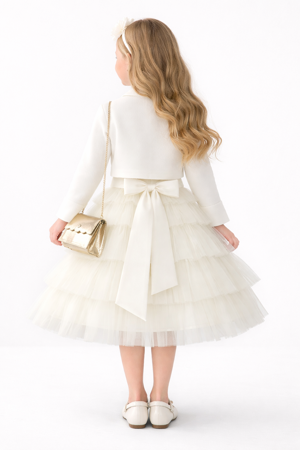 Back view of the ivory flower girl gown showing the elegant oversized satin bow at the waist and the beautiful layers of the tiered tulle skirt.