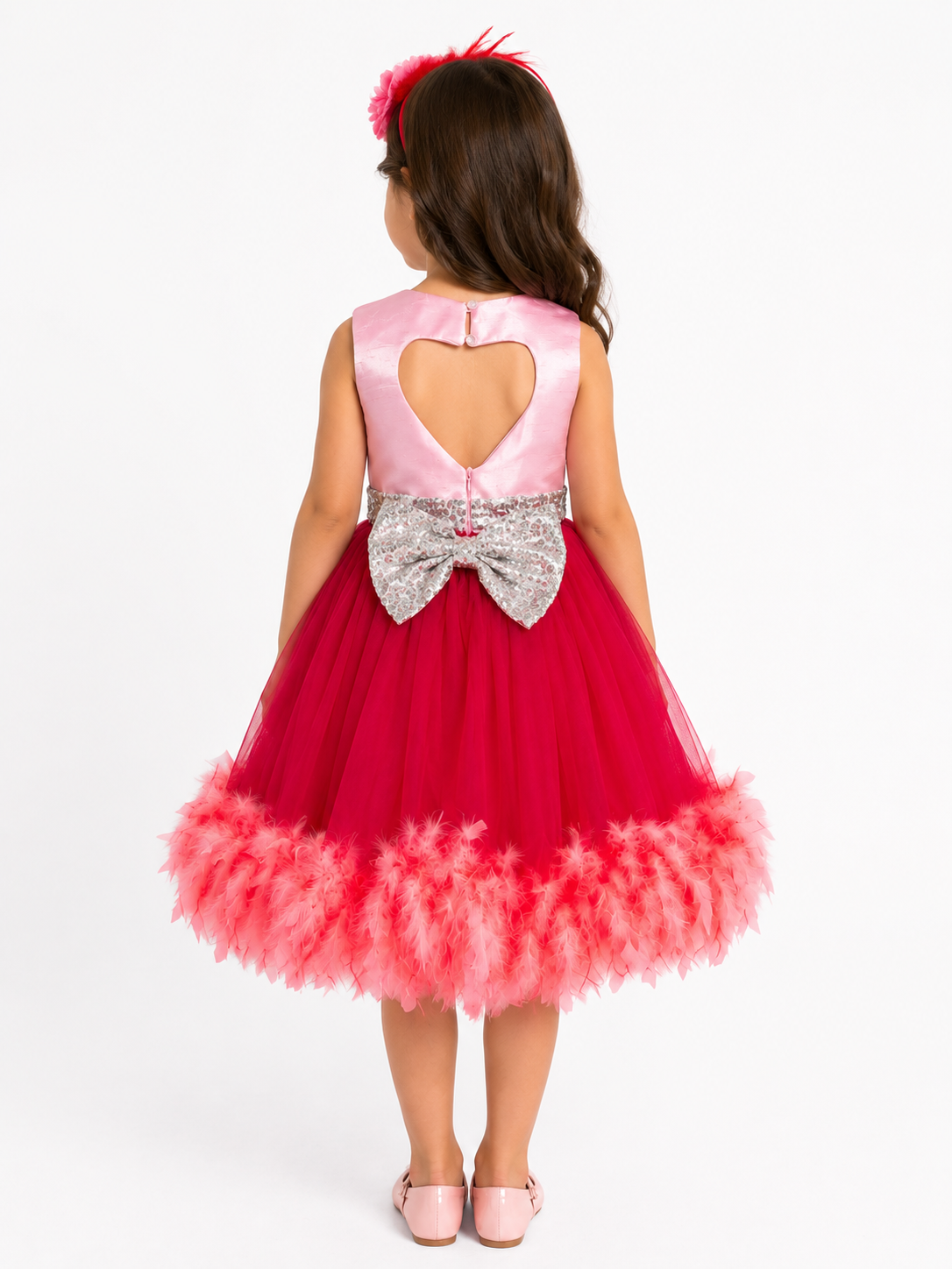 Back view of girl model wearing red princess dress showing heart shape cut out back design and silver sequin bow