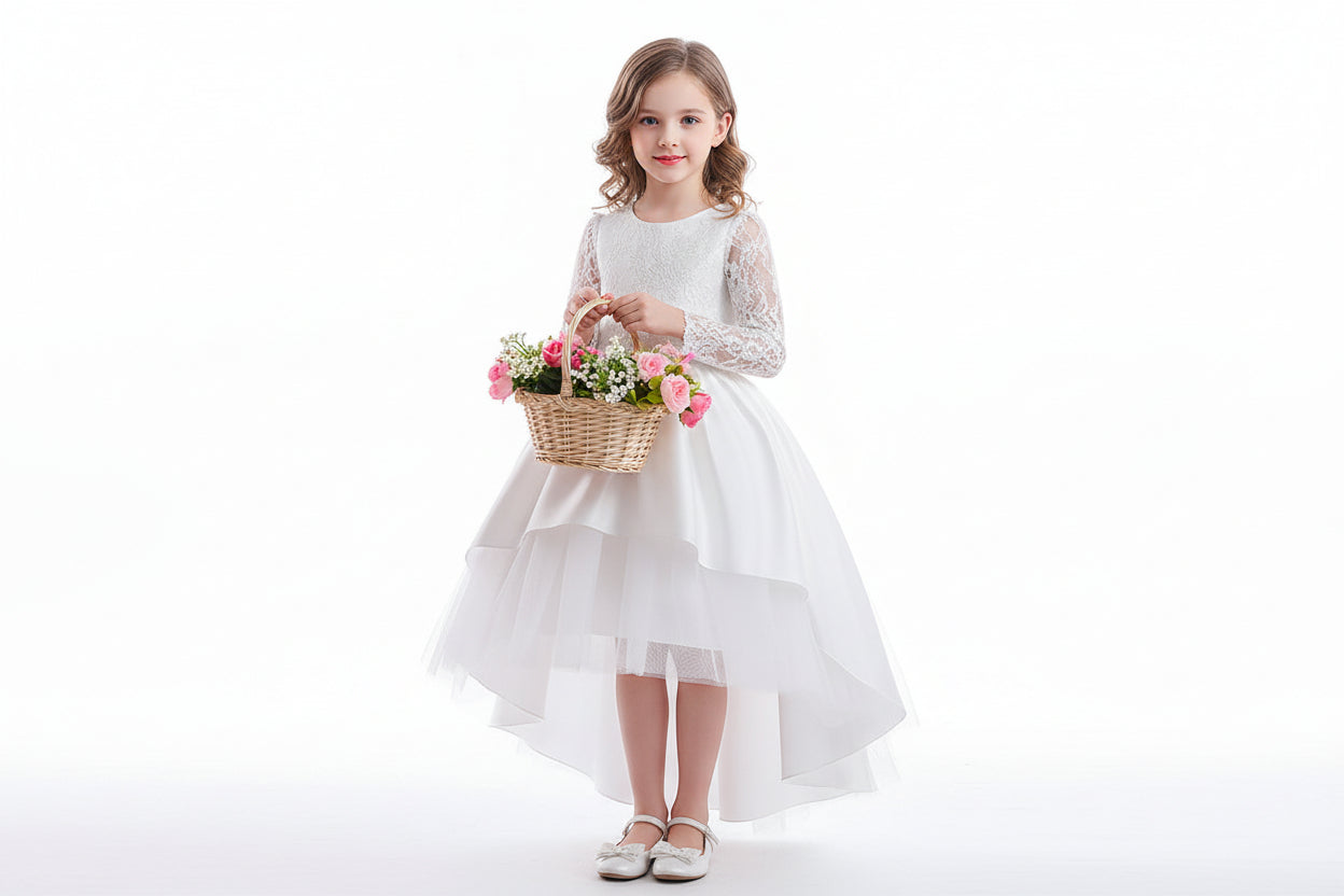 Young girl wearing a white lace long-sleeve flower girl dress with a high-low skirt, holding a basket of pink flowers.