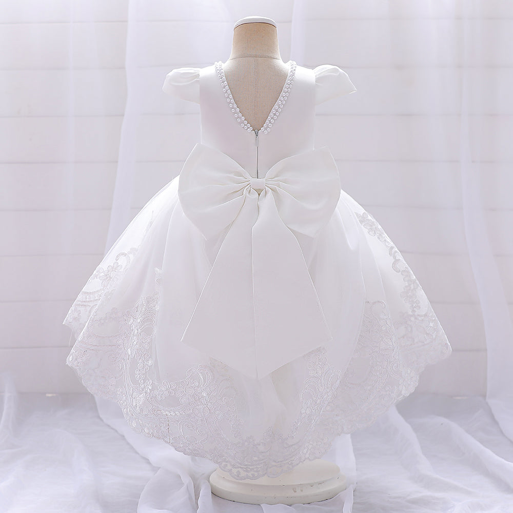 Close-up and back view of a white lace high-low formal dress for toddlers, featuring a large back bow and pearl neck detailing.