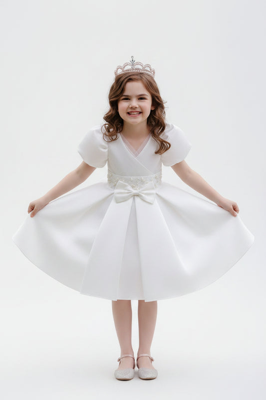 Young girl wearing a white V-neck princess dress with bubble sleeves and a pearl-beaded waist, styled with a tiara for formal occasions.
